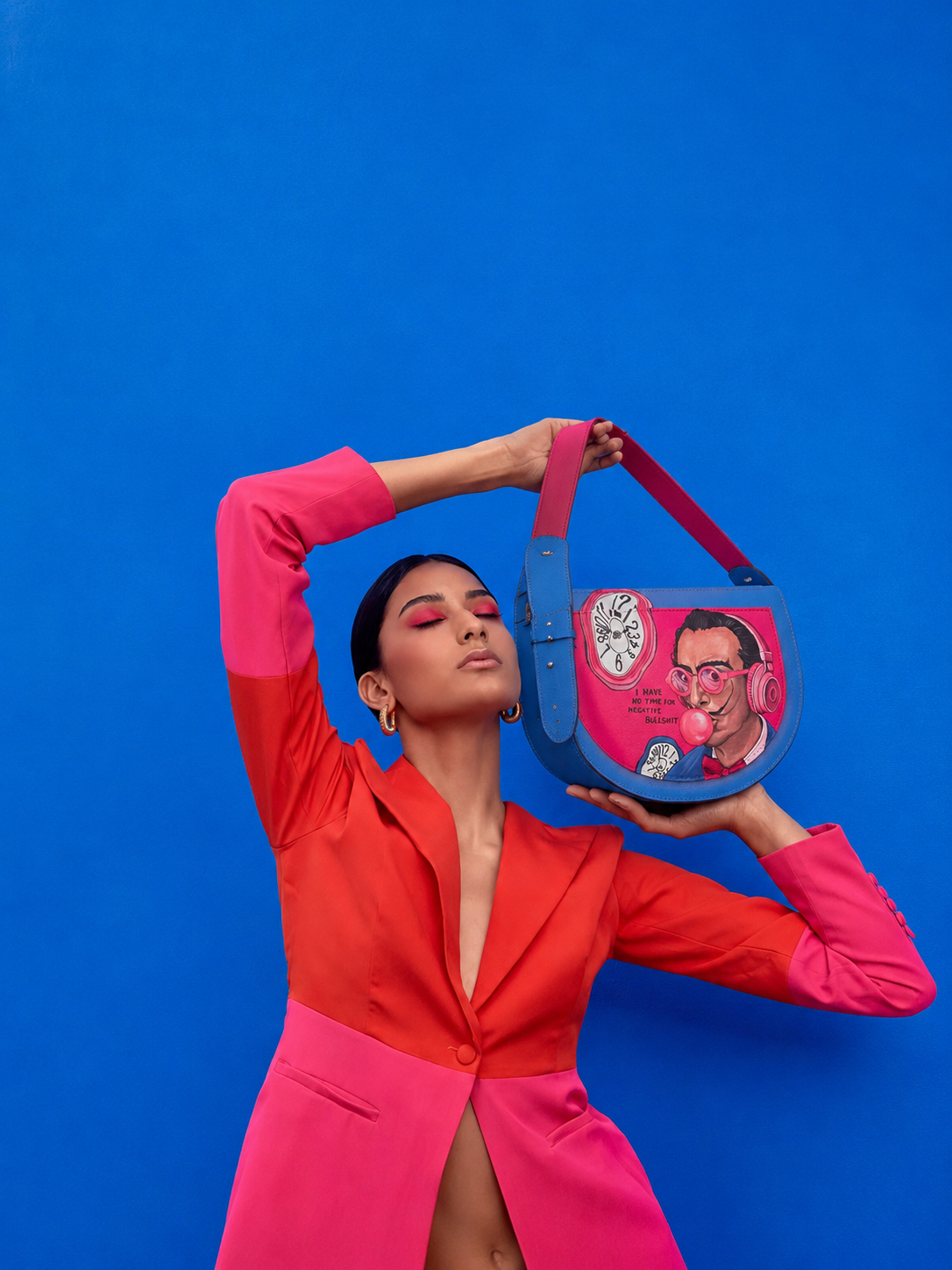 Woman in a pink and red suit carrying a hand-painted SHARENA bag